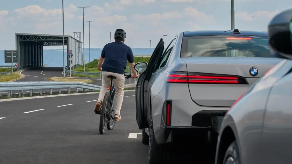 BMW розширює набір систем активної безпеки у своїх нових автомобілях. З появою Neue Klasse компанія почала встановлювати більше таких функцій у стандартній комплектації. Вони можуть допомагати водієві під час руху, паркування та виходу з автомобіля.Однією з найцікавіших новинок стала система Exit Warning. Вона використовує бічні радари, щоб стежити за простором біля припаркованого автомобіля. Якщо до дверей наближається велосипедист, автомобіль або інший учасник руху, електронний замок може тимчасово заблокувати відкривання дверей, доки небезпека не мине.BMW також вдосконалила систему екстреного реагування. У критичній ситуації автомобіль може автоматично загальмувати або виконати маневр ухилення від перешкоди, намагаючись залишитися у своїй смузі. При цьому технологія BMW Symbiotic Drive аналізує дії водія та втручається лише тоді, коли бачить реальний ризик зіткнення.За даними BMW, лише за один місяць автомобілі компанії в Європі подолали близько 1,6 млрд км у межах аналізованого автопарку. Водії отримали приблизно 8 млн попереджень про потенційні зіткнення, а майже у 244 тисячах випадків системи допомоги втручалися кермуванням або гальмуванням.Першим серійним автомобілем Neue Klasse з цими технологіями став BMW iX3. Надалі нові системи безпеки з